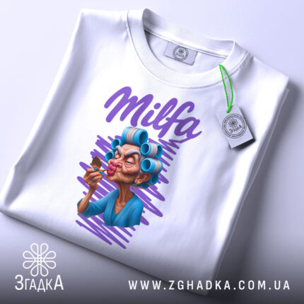 Футболка Milfa білого кольору, складена на поверхні, ракурс зверху, фон світло-сірий, принт з малюнком жінки в блакитному халаті з бігуді, яка тримає морозиво, текст 'Milfa' виконаний фіолетовим кольором, на футболці є етикетка.