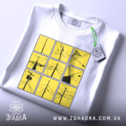Футболка міські дроти, біла, зображена на столі, фон світло-сірий, принт складається з дев'яти квадратів жовтого кольору з чорними малюнками дротів, на футболці є етикетка.
