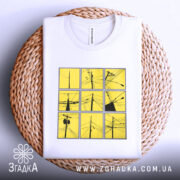 Футболка міські дроти, біла, зображена на столі з плетеним кошиком, фон світло-сірий, принт складається з дев'яти квадратів жовтого кольору з чорними малюнками дротів.