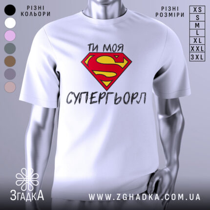 Футболка моя супергьорл, біла, зображена з фронтального ракурсу, фон світло-сірий, принт з червоним логотипом Супермена та текстом "ТИ МОЯ СУПЕРГЬОРЛ" чорного кольору.