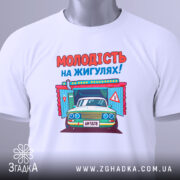 Футболка молодість на жигулях, біла, складена на столі, фон світло-сірий, принт з автомобілем та написом 'МОЛОДІСТЬ НА ЖИГУЛЯХ!' яскравий, з елементами дизайну.