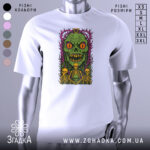 Футболка монстр і скелети, біла, зображена на манекені, фон градієнтний сірий, принт з зеленим монстром з великими оранжевими очима та трьома скелетами, оформлений у фіолетових і зелених кольорах.