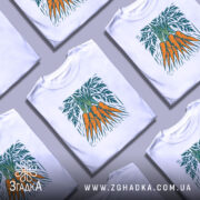 Футболка морква арт, біла, зображена на манекені з правого боку, фон світло-сірий, принт зображує три помаранчеві морквини з зеленим листям.