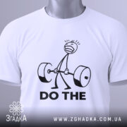 Футболка мотивація для залу, біла, зображена зверху, на ній видно етикетку з зеленим шнурком, фон світло-сірий, принт з малюнком людини, що піднімає штангу, та текстом 'DO THE' чорного кольору.