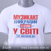 Футболка музикант білого кольору, зображена в плоскому вигляді, з принтом червоного та синього кольорів, текст розташований по центру, на комірці видна етикетка, фон світло-сірий.