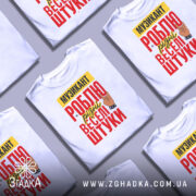 Футболка музикант білого кольору, зображена на манекені, фон світло-сірий, принт містить текст "МУЗИКАНТ РОБЛЮ різні веселі штуки" в червоному, жовтому та чорному кольорах, з малюнком руки в жесті рок-знака.