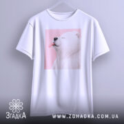 Футболка милий білий ведмедик, біла, підвішена на вішалці, фон світло-сірий, принт ведмедика з висунутим язиком на рожевому фоні.