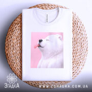 Футболка милий білий ведмедик, біла, складена на плетеній кошику, фон світло-сірий, принт ведмедика з висунутим язиком на рожевому фоні.