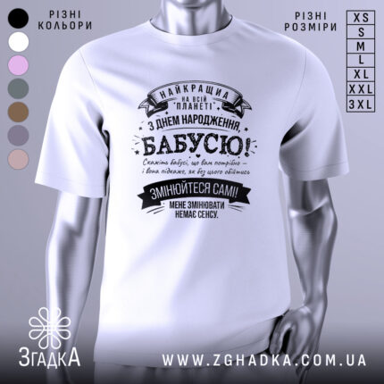 Футболка найкраща бабуся планети, біла, зображена з фронтального ракурсу, на нейтральному фоні, принт чорного кольору з текстом на українській мові та декоративними елементами.