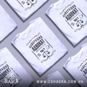 Футболка найкращий адвокат, біла, зображена з фронтального ракурсу на манекені, фон світло-сірий, принт чорного кольору з зображенням ваг та текстом.