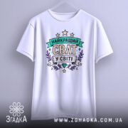 Футболка найкращий сват, біла, зображена з фронтального ракурсу, фон світло-сірий, принт з написом 'НАЙКРАЩИЙ СВАТ У СВІТІ' в кольорах зеленого, фіолетового та жовтого, оточений зірками та рослинними елементами.