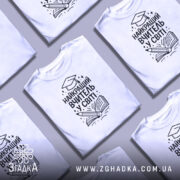 Футболка найкращий вчитель, білого кольору, зображена з правого ракурсу на манекені, фон світло-сірий, принт чорного кольору з малюнком книги та олівця, текст українською мовою.