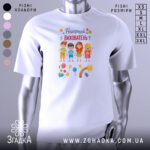 Футболка найкращий вихователь, білого кольору, зображена на манекені з правого ракурсу, фон сірий, принт містить малюнки дітей, квітів, сонця та веселки.