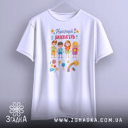 Футболка найкращий вихователь, білого кольору, зображена на манекені з фронтального ракурсу, фон сірий, принт містить малюнки дітей, квітів, сонця та веселки.