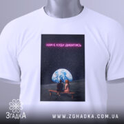 Футболка нам є куди дивитись. Біла футболка, складена на поверхні, з принтом, на якому видно двох людей, що сидять на лавці під землею, оточеними зоряним небом. Текст на принті яскравий, неоновий.