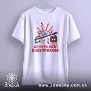 Футболка не бути електриком. Біла футболка на манекені, з принтом червоного кольору, що зображує електричний шнур і напис "НЕ БУТИ МЕНІ ЕЛЕКТРИКОМ!". Фон світло-сірий, деталі принта яскраві та контрастні.