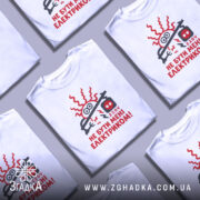 Футболка не бути електриком. Біла футболка на манекені, з принтом червоного кольору, що зображує електричний шнур і напис "НЕ БУТИ МЕНІ ЕЛЕКТРИКОМ!". Фон світло-сірий, деталі принта чіткі та яскраві.