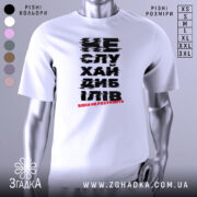 Футболка не слухай дебілів, біла, зображена з фронтального ракурсу на манекені, фон нейтральний, принт чорного кольору з червоним акцентом, текст розмитий.