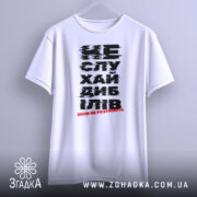 Футболка не слухай дебілів, біла, зображена з фронтального ракурсу, фон світло-сірий, принт чорного кольору з червоним акцентом, текст розмитий.