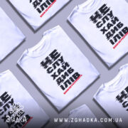 Футболка не слухай дебілів, біла, зображена з фронтального ракурсу на манекені, фон нейтральний, принт чорного кольору з червоним акцентом, текст розмитий.