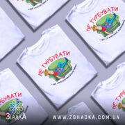 Футболка не турбувати, біла, з принтом на грудях, зображення хлопця, що лежить на зеленому дивані, тримаючи в руках газету, текст червоним кольором.