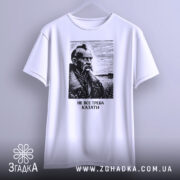 Футболка не все треба казати, біла, підвішена на вішалці, фон світлий, принт з портретом чоловіка з вусами та бородою, напис під портретом: 'НЕ ВСЕ ТРЕБА КАЗАТИ'.