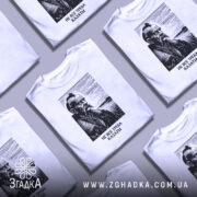 Футболка не все треба казати, біла, зображена на манекені, фон градієнтний сірий, принт з портретом чоловіка з вусами та бородою, напис під портретом: 'НЕ ВСЕ ТРЕБА КАЗАТИ'.