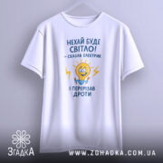 Футболка нехай буде світло. Біла футболка на вішалці, ракурс спереду, фон світлий, принт з жовтою лампочкою та текстом у синьому кольорі.