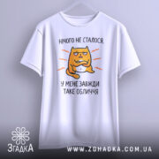 Футболка нічого не сталося. Біла футболка, підвішена на фоні світло-сірого кольору, з принтом жовто-оранжевого кота, що має вираз обличчя, текст 'У МЕНЕ ЗАВЖДИ ТАКЕ ОБЛИЧЧЯ'. Футболка має короткі рукави і округлий виріз.