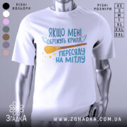 Футболка обріжуть крила, біла, зображена з фронтального ракурсу, на фоні світло-сірого градієнту, принт містить текст з жартівливим змістом та малюнок мітли з зірочками.
