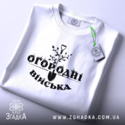 Футболка огородні війська, біла, складена на поверхні, з видимим етикеткою, фон світло-сірий, принт чорного кольору з лопатою та рослинами.