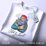 Футболка Old School білого кольору, розкладена на поверхні, з принтом старшого чоловіка з бородою, який тримає пляшку та сигару, на фоні світло-блакитного кольору, деталі принта чіткі, з етикеткою на комірці.