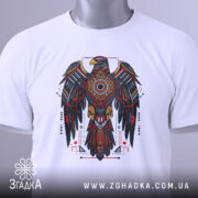 Футболка орел бойовий дух, біла, зображена зверху, складена на поверхні, фон світло-сірий, принт з орлом в червоних, чорних і золотих кольорах, з етикеткою на зеленому шнурку.