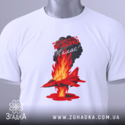 Футболка Палаючий літак, біла, зображена зверху, на фоні світлого градієнту. Принт з червоним літаком, що летить через полум'я, з текстом на чорному фоні, з зеленим ярликом.
