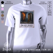 Футболка памʼять 24 лютого, біла, зображена на манекені, фон нейтральний, принт з палаючими будинками та написом "24.02.2022".