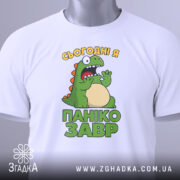 Футболка панікозавр білого кольору, складена на поверхні, з видимим етикеткою, фон світло-сірий, принт з динозавром та написом 'Сьогодні я панікозавр' у яскравих кольорах.