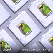 Футболка папуга у окулярах, біла, зображена на манекені, фон світло-сірий, принт з яскравим зеленим папугою в окулярах, текст під ним: 'Why are you looking at me?'