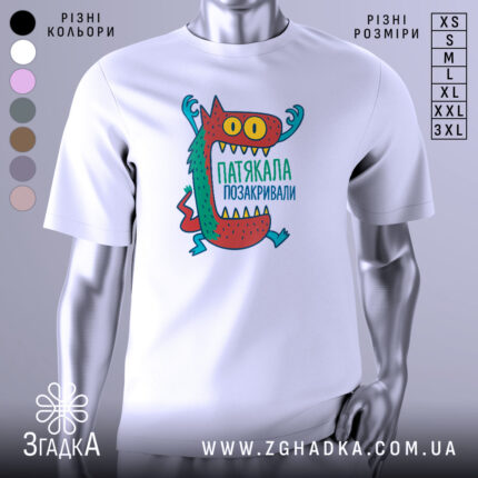 Футболка патякала позакривали, біла, зображена з фронтального ракурсу, фон нейтральний, принт з веселим монстром з великими очима та зубами, кольори принта червоний, зелений, жовтий та блакитний.