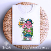 Футболка патрик у відпустці, біла, складена на плетеній кошику, фон світлий, принт з мультяшним персонажем у зеленій сорочці з квітковим малюнком, з годинником на руці та капелюсі.