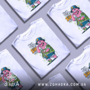 Футболка патрик у відпустці, біла, зображена з фронтального ракурсу на манекені, фон нейтральний, принт з мультяшним персонажем у зеленій сорочці з квітковим малюнком, з годинником на руці та капелюсі.