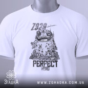 Футболка perfect hero арт білого кольору, складена на поверхні, з видимим етикеткою. Принт зображує персонажа з великими очима та текстом 'PERFECT HERO', на фоні світлого градієнта.
