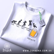 Футболка п’ятниця еволюція, біла, складена на столі, фон світло-сірий, принт з еволюцією людини, текст 'FRIDAY!!!' під малюнком, на футболці є етикетка.