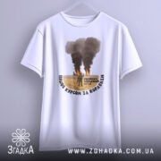 Футболка пішов курсом. Біла футболка, підвішена на вішалці, з принтом, що зображує військову сцену. Принт розташований по центру, текст чорного кольору обрамляє зображення. Фон нейтральний, світло-сірий.