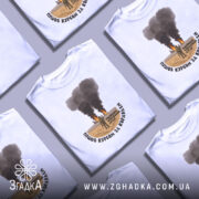 Футболка пішов курсом. Біла футболка на манекені, з принтом, що зображує військову сцену з димом і вогнем на фоні. Принт розташований по центру, текст чорного кольору обрамляє зображення. Фон нейтральний, світло-сірий.