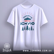 Футболка подорожую отже існую, біла, зображена спереду, на фоні світло-сірого кольору, принт з горами, деревами та текстом, з широкими рукавами.