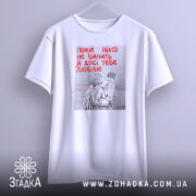 Футболка поки ніхто не бачить, біла, зображена з фронтального ракурсу, фон світлий, принт з двома фігурами в смугастих костюмах, текст червоним кольором: 'Поки ніхто не бачить Я досі тебе люблю'.