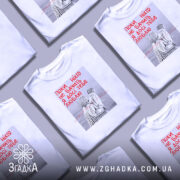 Футболка поки ніхто не бачить, біла, зображена на манекені, фон нейтральний, принт з двома фігурами в смугастих костюмах, текст червоним кольором: 'Поки ніхто не бачить Я досі тебе люблю'.