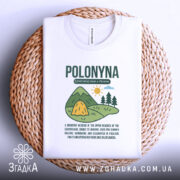 Футболка полонина карпати, біла, складена на плетеній кошику, фон світлий, принт з малюнком гір, сонця та текстом про полонину.