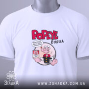 Футболка Popeye борщ, біла, складена на поверхні, фон світло-сірий, принт з Попаєм, який тримає банку борщу, текст червоним кольором, на комірці є етикетка.