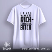 Футболка працюй будь багатим. Біла футболка, підвішена на вішалці, з фронтального ракурсу. Фон світлий, з легким градієнтом. Принт містить текст: 'IF YOU WANNA BE RICH- йди працею, BITCH'.